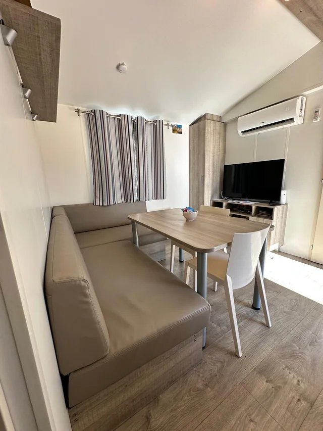 Salon climatisé avec télévision et table à manger